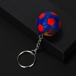 Close-up of red and blue FCB soccer ball keychain with metallic ring and stitch detail