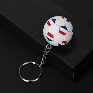 Detailed view of 3D football keychain with red white and blue pattern on black surface