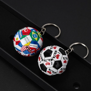 Mini-Fußball-Schlüsselanhänger mit Nationalflaggen und Malta-Design auf schwarzem Tablett