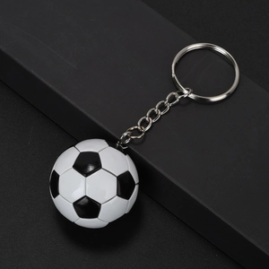 Close-up of a classic mini soccer ball keychain with silver metal chain on black background