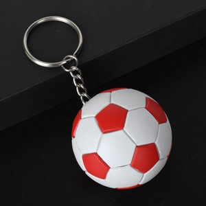 Dettaglio portachiavi calcio bianco e rosso con anello in metallo su supporto nero