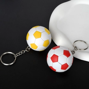 Dettaglio ravvicinato di portachiavi a forma di calcio in rosso e giallo su nero