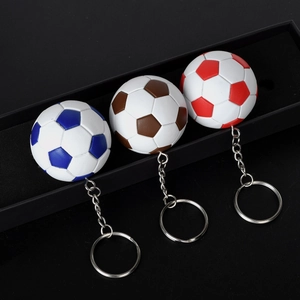 Vista dettagliata di portachiavi da calcio in rosso, blu e marrone in una scatola regalo