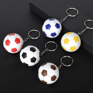 Cinque portachiavi a forma di pallone da calcio in pelle PU su un piedistallo nero
