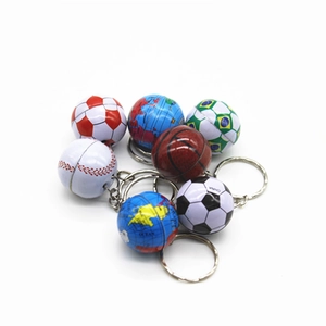 Cluster of miniature sports ball and globe keychains with metal rings on white background