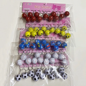 Close-up of sports themed keychains including basketball and soccer balls in retail packaging