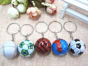 Detailed view of five mini sports keychains including soccer and basketball on burlap