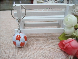 Close-up of orange and white football keychain charm with silver metal ring