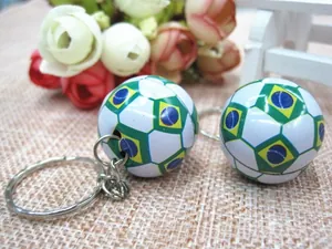 Close-up of Brazil flag themed soccer ball keychains with metallic ring and green yellow finish