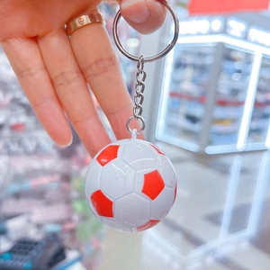 Dettaglio di un portachiavi mini pallone da calcio rosso e bianco con trama cucita classica