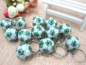Close-up of mini black and white football keychain with printed Brazil flag emblem