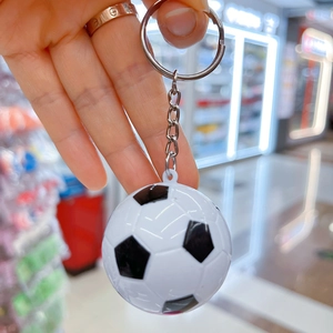 Dettaglio ravvicinato di un mini portachiavi da calcio bianco e nero con anello in metallo