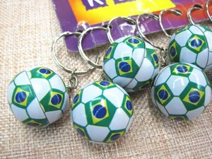 Macro shot of Brazil flag themed mini football keychain with metallic keyring on fabric
