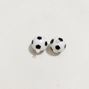 Dettaglio di due mini portachiavi a forma di pallone da calcio bianco e nero con anelli