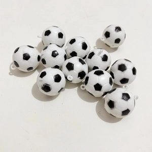 Dettaglio di mini ciondoli da calcio in bianco e nero con anellini per portachiavi fai-da-te