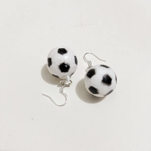Dettaglio degli orecchini pendenti a mini pallone da calcio bianco e nero lucidi