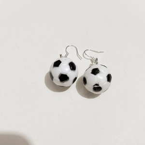 Dettaglio macro di orecchini mini pallone da calcio bianco e nero con ganci in argento