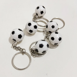 Vista dall'alto di sei portachiavi a forma di calcio in PVC bianco e nero con anelli