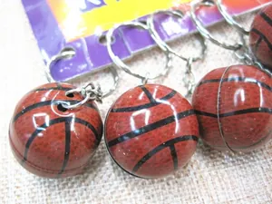 Close-up of brown basketball keychains with black stripe texture and silver metal rings