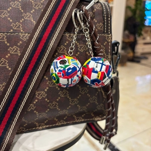 Detail von Fußball-Schlüsselanhängern mit Nationalflaggen und Namen an Taschenhaken