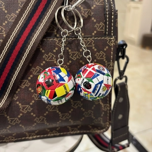Fußball Schlüsselanhänger mit Nationalflaggen an einer gemusterten Ledertasche