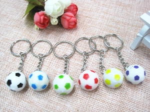 Dettaglio di sei mini portachiavi a pallone da calcio in PVC colorato con anello