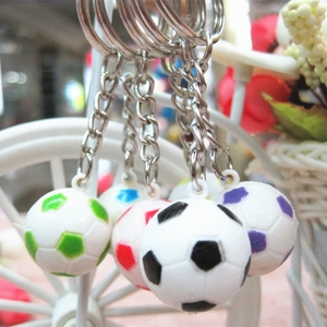 Dettaglio di portachiavi a forma di pallone in PVC colorato appesi a un supporto bianco