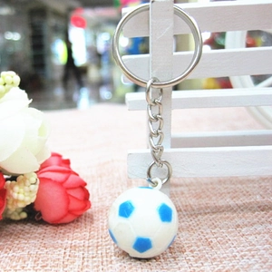 Primo piano di un mini portachiavi a pallone da calcio blu e bianco su uno sgabello