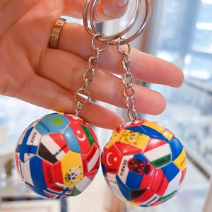 Nahaufnahme eines Fußball-Schlüsselanhängers mit Nationalflaggen wie Deutschland in der Hand