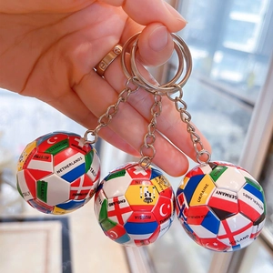 Nahaufnahme der Weltflaggen-Fußball-Schlüsselanhänger mit Metallringen in der Hand