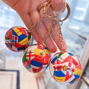 Detailansicht von drei Fußball-Schlüsselanhängern mit verschiedenen Nationalflaggen und Ringen