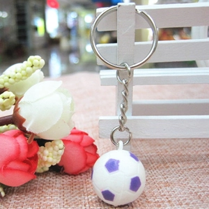 Dettaglio di un mini portachiavi a pallone da calcio bianco e viola con catena
