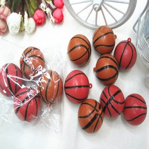 Dettaglio di mini ciondoli a forma di basket in arancione e rosso con trame nere