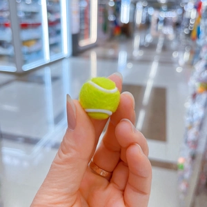Detailansicht eines Mini-Tennisball-Anhängers in fluoreszierendem Grün mit flauschiger Textur