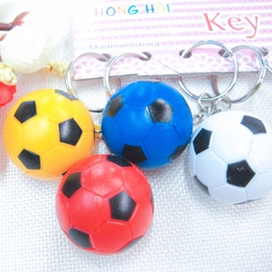 Detail of soccer ball keychains in red, blue, yellow, and white on card packaging