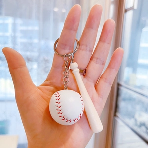 Mini honkbal en houten knuppel sleutelhanger met zilveren ring in de hand