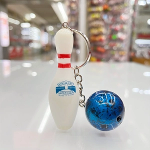 Detail van bowling pin sleutelhanger met rode strepen, blauwe bal en metalen ring
