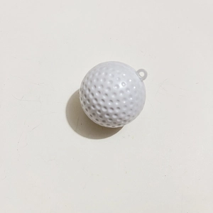 Detailed view of a white golf ball shaped keychain with realistic textured dimples
