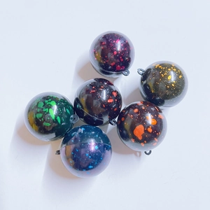 Detailed view of six miniature sports balls with colorful splatter patterns and hanging loops