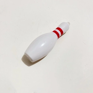 Detail view of mini bowling pin keychain with red stripes on a white background