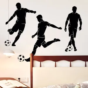 Detailed view of black football player silhouettes and soccer ball wall decals on bedroom wall