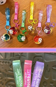 Detail of creative football keychains with colorful glitter straps and liquid charms