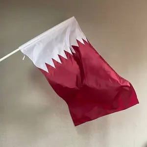 Qatar national flag made of durable polyester with a white handheld flagpole on grey wall