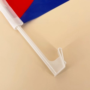 Close-up of a white plastic car window flag pole with a secure hook for travel