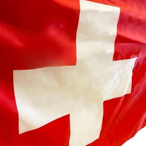Detail of Swiss flag showing red fabric with white cross and fine polyester texture