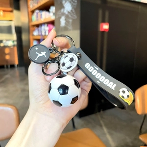 Soccer keychain with ball pendant and GOOOOOAL rubber wristlet strap shown in hand