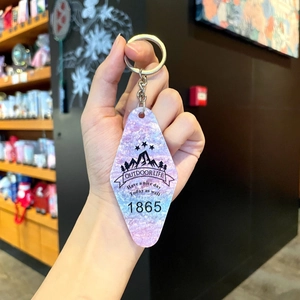 Detail of rhombic acrylic keychain with purple pearlescent finish and outdoor graphics