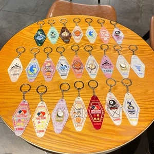 Diamond shaped acrylic keychains with retro sports motifs on a wooden table