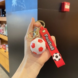 Détail du porte-clés football 3D rouge et blanc avec sangle en caoutchouc et métal doré