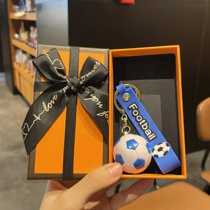 Vue détaillée du porte-clé football bleu avec bracelet silicone en boîte cadeau